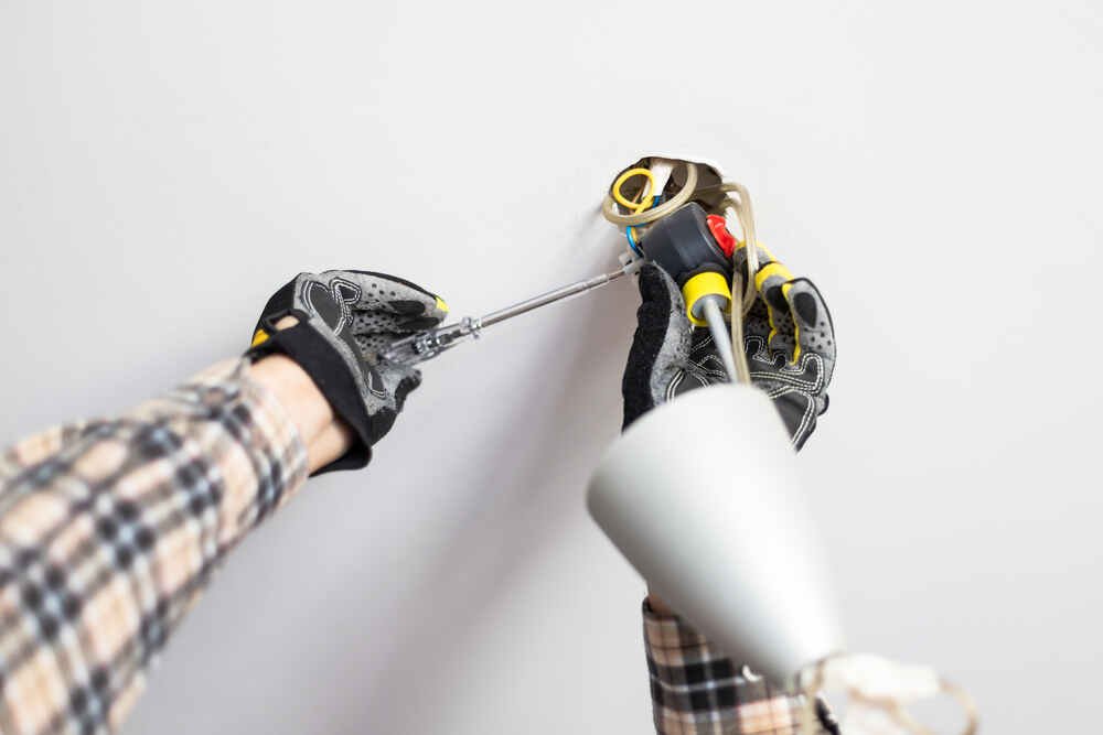 Electrician installing ceiling fan. Blackhorse Electrical, London.